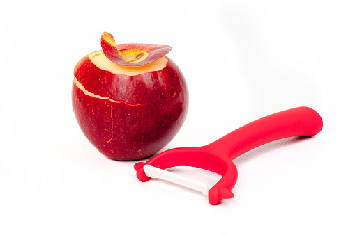 Red apple peeled  and knife on white