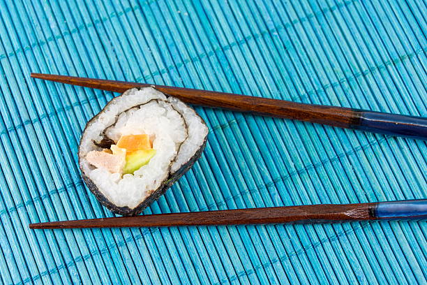 rolo de sushi efectuadas por pauzinhos - cought imagens e fotografias de stock