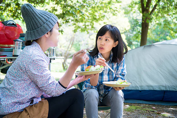 istock Two friends sat talking at a campsite whilst eating 528562066