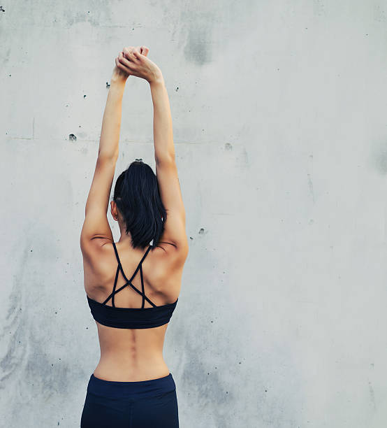 istock Woman stretching arms up extending back muscles 528562540