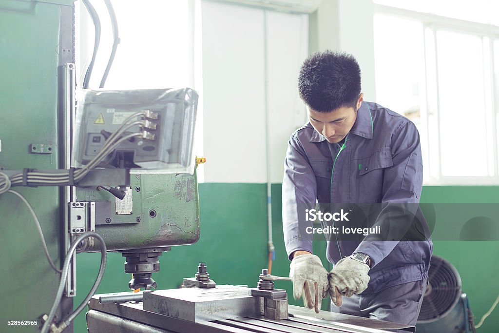 mechanic worker busy working on machine in factory Adult Stock Photo