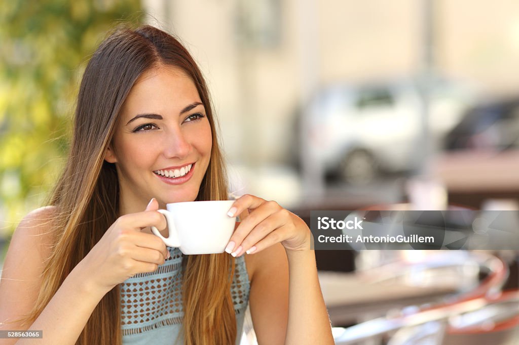 Pensive woman thinking in a coffee shop terrace Happy pensive woman thinking in a coffee shop terrace in the street Coffee - Drink Stock Photo