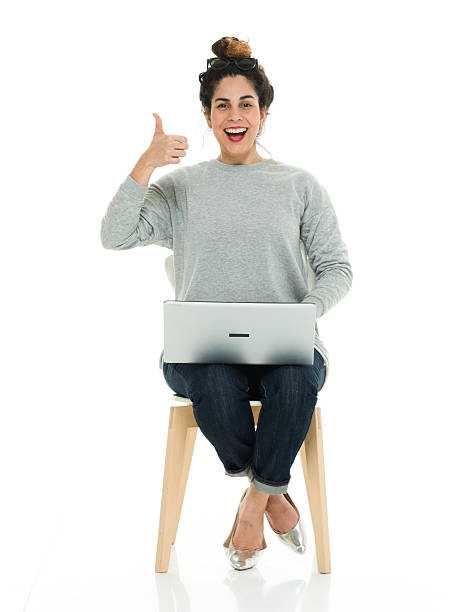 istock Smiling woman sitting and showing thumbs up 528564200