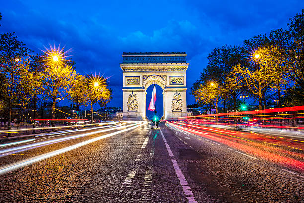 Arc de Triomphe - Paris Traffic at Avenue des Champs-Elysses leading to the Arc de Triomphe. arc de triomphe paris stock pictures, royalty-free photos & images