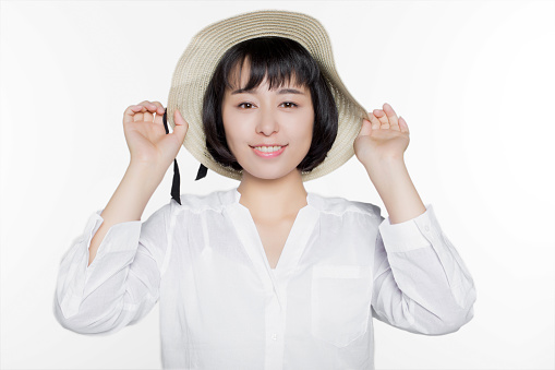 chinese girl in the room, dressed in casual clothes with a straw hat, isolated on white studio