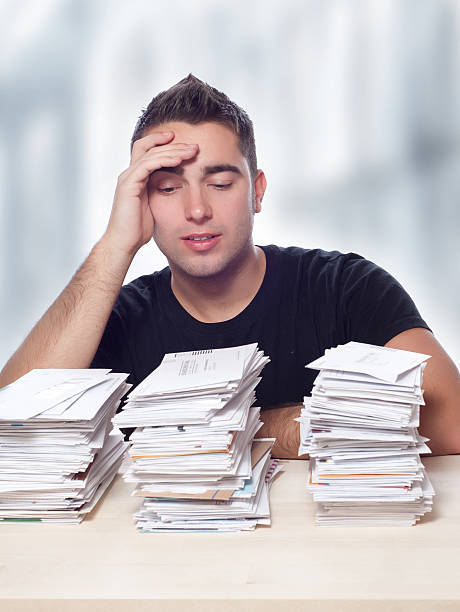 istock Young Man with Unpaid Mortagage, Studen Loan, Credit Card Bills 528566216