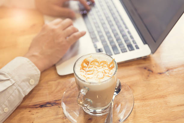 istock man's hand working with laptop computer with hot latte coffee 528566496