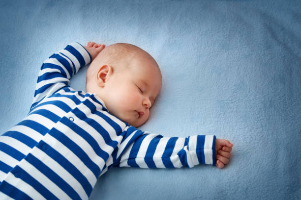 Baby sleeping in bed stock photo