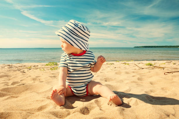 istock Little baby boy sitting on the beach in summer day 528567748