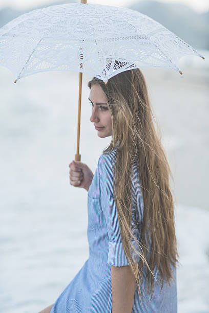 istock Young women with a umbrella on the beach 528567822