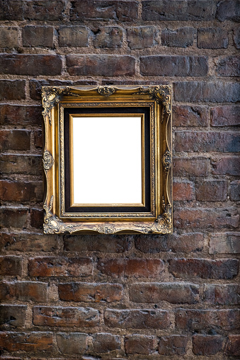 Old brick wall with ornate gold frame with copy space.