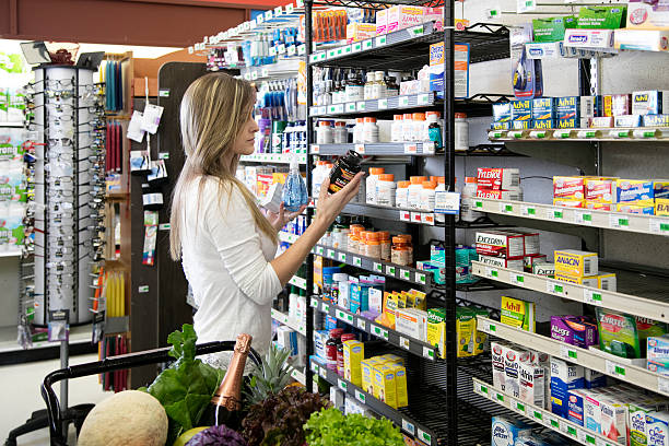 Woman shopping for health and beauty supplies Woman shopping in store buying health and beauty supplies nutritional supplement stock pictures, royalty-free photos & images