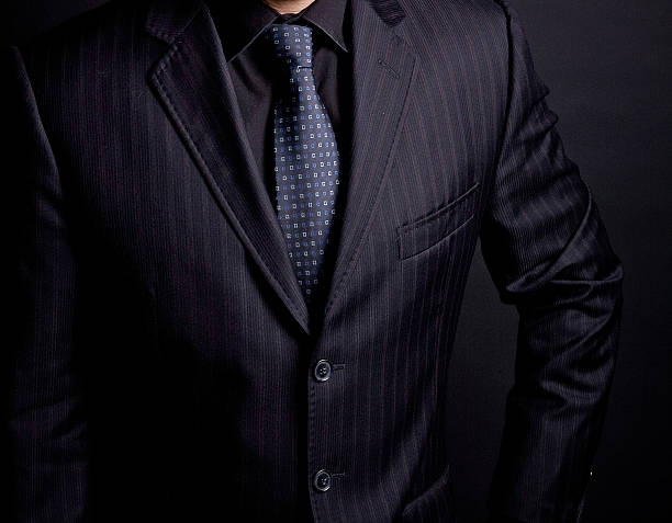 istock man in suit on a black background. studio shot 528570156