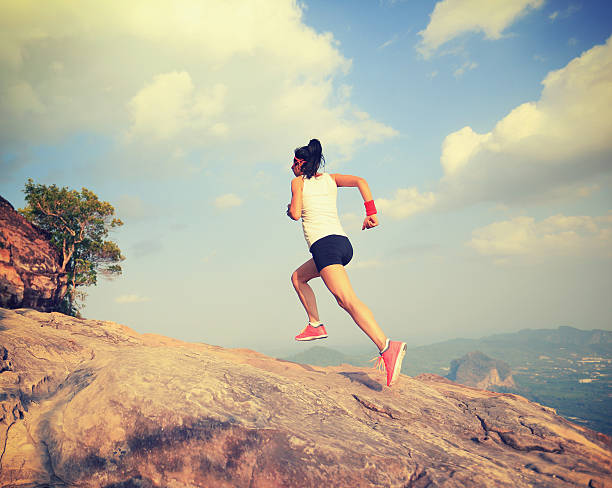 istock young asian woman runner running on mountain peak 528571412