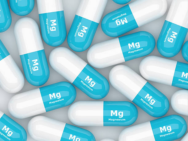 magnesium pills lying on white table stock photo