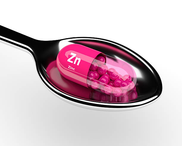 3 d zinco de comprimidos em uma colher sobre o branco - zinc mineral nutritional supplement pill - fotografias e filmes do acervo