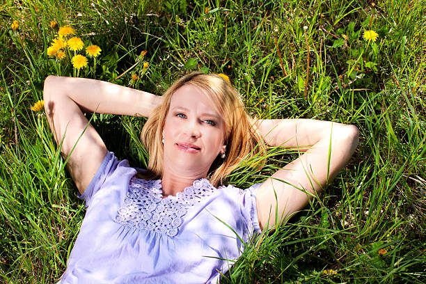 istock Happy matured woman lying in the grass 528579090