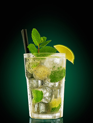 mojito cocktail served in glass with ice, mint and slices of lime.