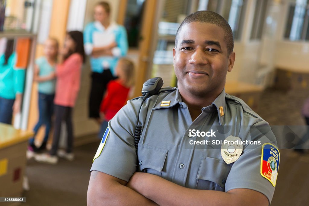Friendly school security guard working on elementary school campus Police Force Stock Photo