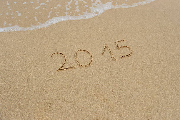 The numbers of the year 2015 written in the wet sand at the beach