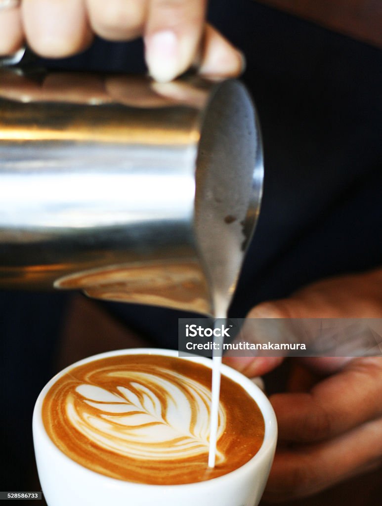 hand of barista making latte or cappuccino coffee hand of barista making latte or cappuccino coffee pouring milk making latte art Adulation Stock Photo