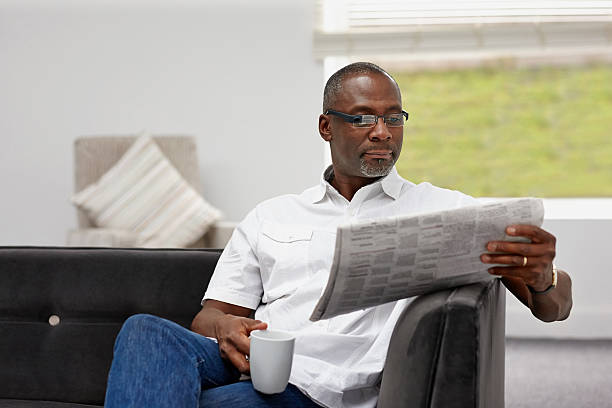 elegante homem maduro africano lendo jornal - reading newspaper 30s adult - fotografias e filmes do acervo