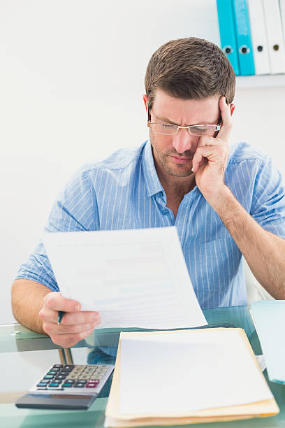 istock Businessman reading document at desk in office 528587697
