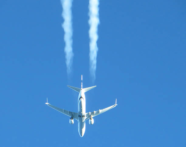 Boeing 737-900 Max Airplane Overhead inflight Boeing 737-900 Max inflight overhead,inflight with contrails. ringer stock pictures, royalty-free photos & images