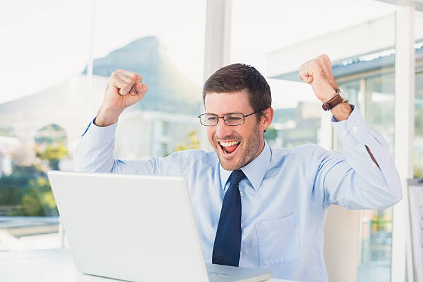 istock Cheering businessman at his desk 528589021