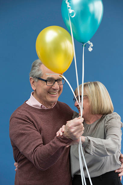 istock Couple dancing and laughing with balloons in hand 528605658