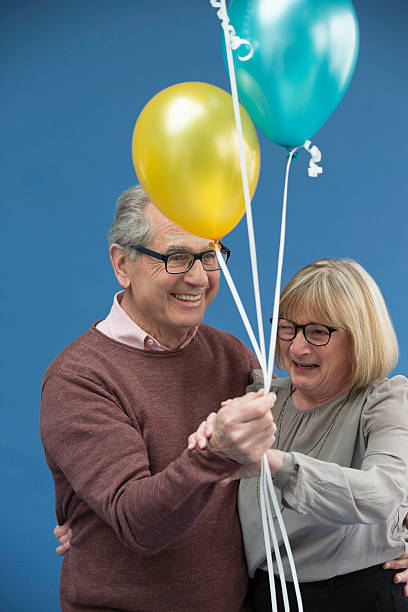 istock Senior couple dancing and laughing with balloons in hand 528606066