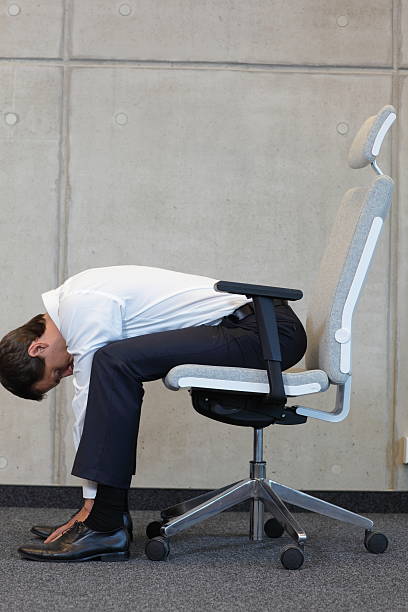 yoga with chair in office - business man exercising in office stock photo