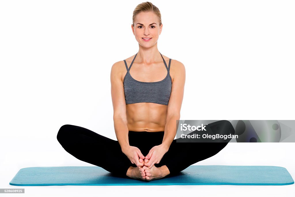 Young fitness woman practicing yoga on white background Athletic and flexible young woman, doing a yoga standing asana on a white, isolated background. Activity Stock Photo