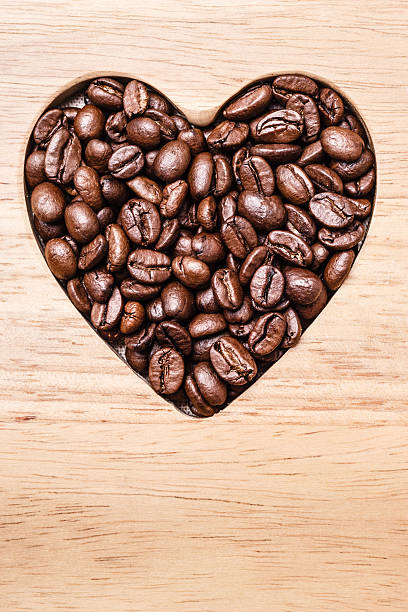 istock Heart shaped coffee beans on wooden board 528611232