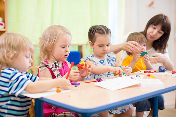 istock kids learning arts and crafts in kindergarten with teacher 528611932
