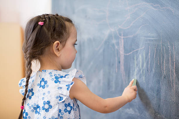 istock little girl side view near blackboard 528612254