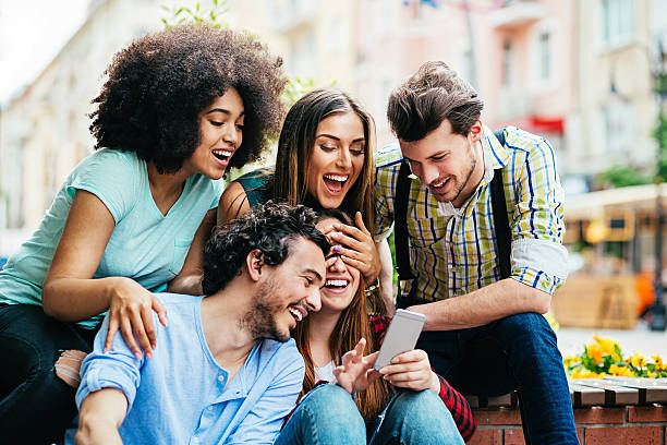 istock Multi-ethnic group of friends having fun with a phone 528613202