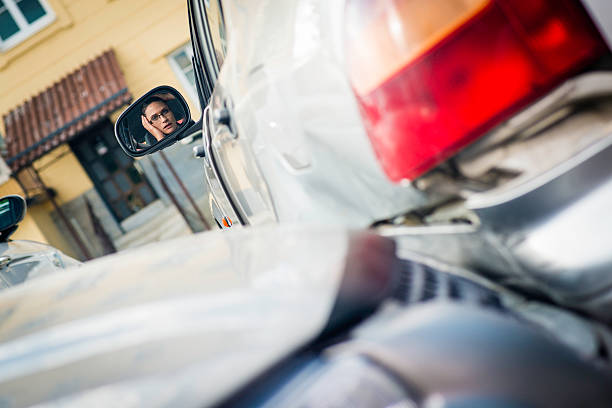 Woman Having a Parking Lot Accident Woman's face in side-view mirror after having a car accident on the parking lot. broken side view mirror stock pictures, royalty-free photos & images