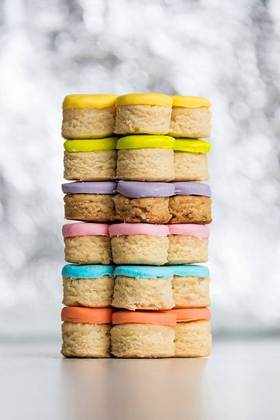 Colorful homemade fondant covered cookies on a shiny light background