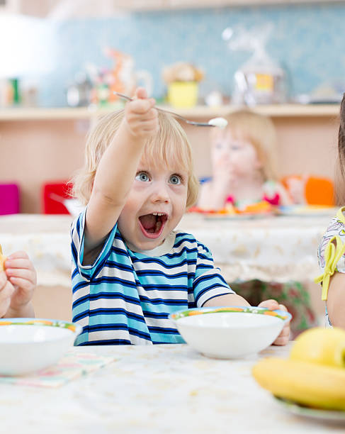 istock Funny kid playing during meal in kindergarten 528618120
