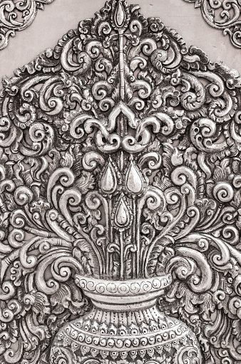 Chiang Mai, Thailand – March 19, 2016: Thai style silver carving plate is stick on temple wall at Srisuphan  temple