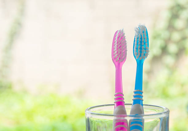old two toothbrushes in glass stock photo