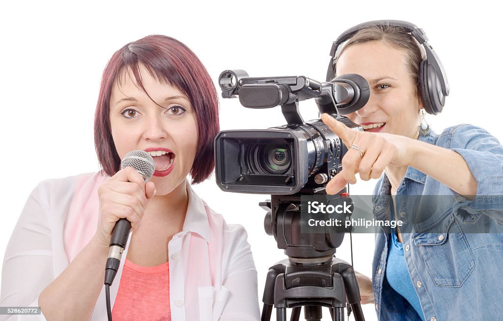 young woman journalist with a microphone and camerawoman a young woman journalist with a microphone and camerawoman Adult Stock Photo