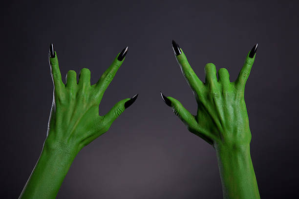 istock Green monster hands with black nails showing heavy metal gesture 528621462