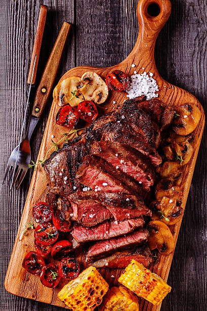 istock Beef steaks with grilled tomatoes, mushrooms and corn. 528621866