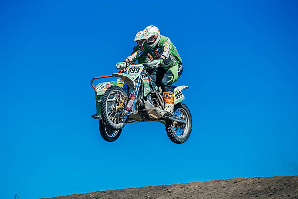 Two dirt bike riders on a dirt race track.