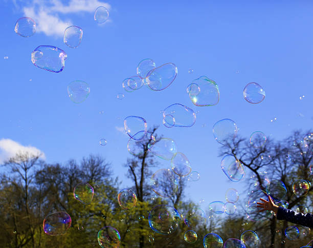 istock Delicate soap bubbles and kids hand in the park 528624348