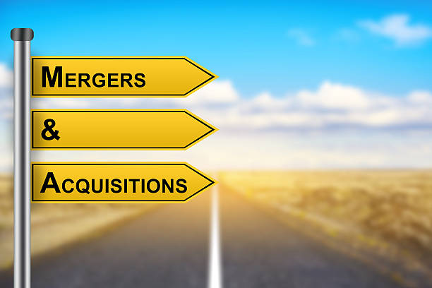 M&A or Mergers and Acquisitions words on yellow road sign stock photo