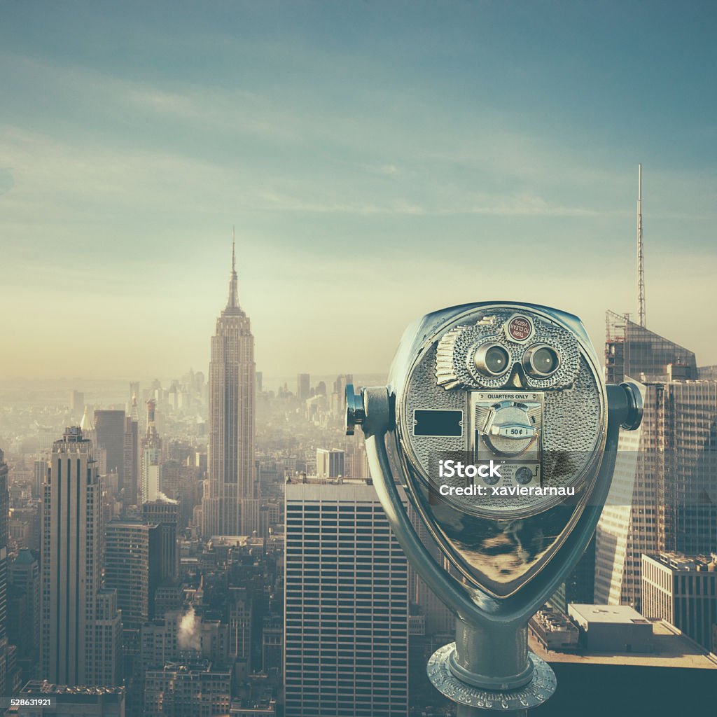 New York cityscape Composite image of binoculars with the cityscape of New York. Coin-Operated Binoculars Stock Photo