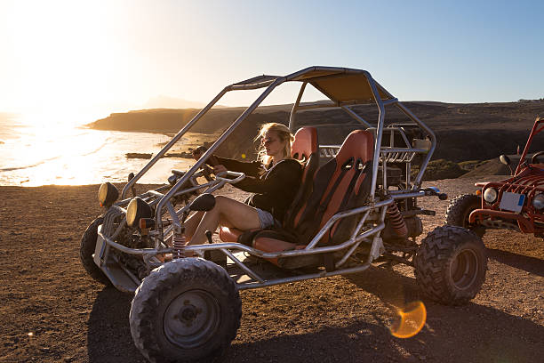 kobieta jazdy quad o zachodzie słońca. - beach buggy zdjęcia i obrazy z banku zdjęć